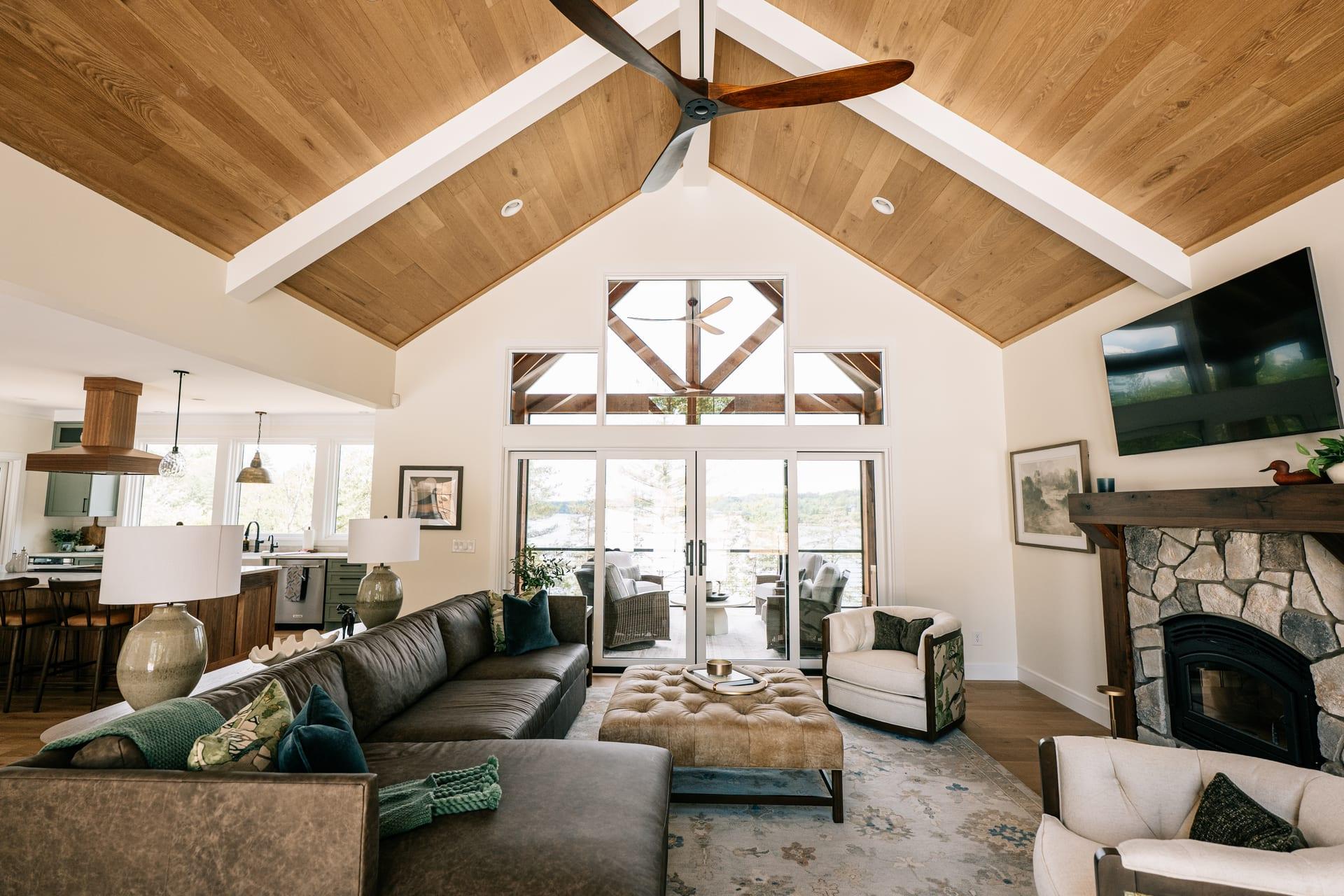 Vaulted timber-frame great room with stone fireplace inside a JCM custom home at Capitol Peak Summit